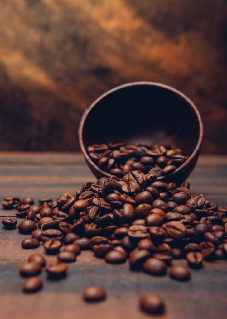 L'immagine attuale non ha un testo alternativo. Il nome del file è: chicchi-di-caffe-scuri-una-ciotola-su-una-tabella-marrone-scaled.jpg
